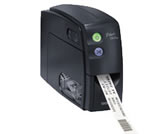 Brother P-touch PT-2500PC dark desktop label printer with a short printed label exiting the front